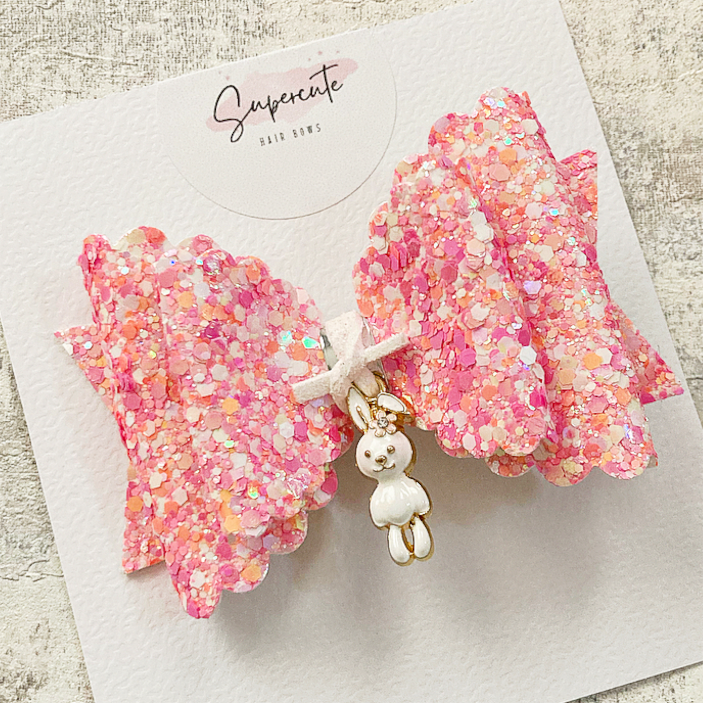 A pink mix chunky glitter hair bow with a little rabbit dangling charm 