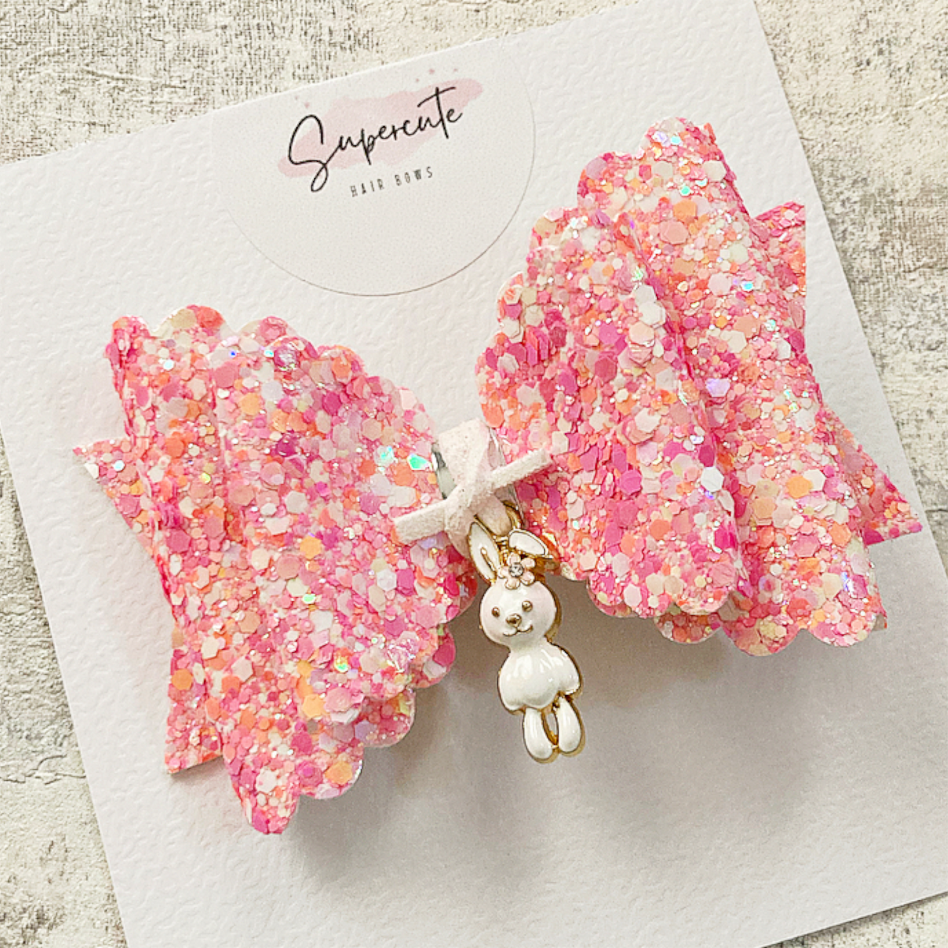 A pink mix chunky glitter hair bow with a little rabbit dangling charm 